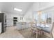 Well-lit kitchen and breakfast nook featuring white cabinets, stainless steel appliances, and a glass top table at 2821 E Pontiac Dr, Phoenix, AZ 85050