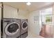 Convenient laundry room featuring a modern washer and dryer set and built-in cabinets for storage at 2821 E Pontiac Dr, Phoenix, AZ 85050