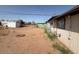 Spacious dirt backyard with detached garage and utilities along the back of the home at 3155 E Mobile Ln, Phoenix, AZ 85040