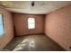 Empty bedroom featuring brick walls and a worn concrete floor at 3155 E Mobile Ln, Phoenix, AZ 85040