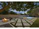 Expansive backyard with a stylish fire pit, pool with fountains, and cozy seating area at 4300 S Marble St, Gilbert, AZ 85297
