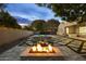 Gorgeous backyard featuring a pool, spa, stone fire pit, and comfortable seating area under mature trees at 4300 S Marble St, Gilbert, AZ 85297