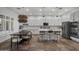 Open-concept kitchen with stainless steel appliances, white cabinets, island seating, and a dining area at 4300 S Marble St, Gilbert, AZ 85297