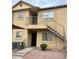 Exterior view of a two-story tan apartment building with stairs leading to the second level entry at 653 W Guadalupe Rd # 2019, Mesa, AZ 85210