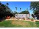 Backyard recreation area with mature trees, potted plants, and desert landscaping at 7537 W Bluefield Ave, Glendale, AZ 85308