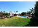 Expansive backyard with lush lawn, swimming pool, and covered patio area at 7537 W Bluefield Ave, Glendale, AZ 85308