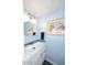 Powder room features a modern vessel sink with a circular mirror and blue accent wall at 7537 W Bluefield Ave, Glendale, AZ 85308