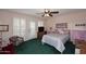 Cozy bedroom with green carpet, plantation shutters, a ceiling fan, and coordinated furniture at 7537 W Bluefield Ave, Glendale, AZ 85308