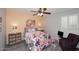 Cozy bedroom featuring floral bedding, ceiling fan, and matching bedside tables with ample storage at 7537 W Bluefield Ave, Glendale, AZ 85308