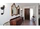 Elegant foyer featuring a carved wood door, brick flooring, and decorative mirrors at 7537 W Bluefield Ave, Glendale, AZ 85308