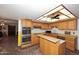 Functional kitchen with oak cabinetry, stainless appliances and breakfast bar at 7537 W Bluefield Ave, Glendale, AZ 85308