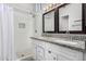 Well-lit bathroom with double sinks, granite countertop, and a tiled walk-in shower at 960 W Hudson Way, Gilbert, AZ 85233