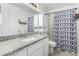 Well-lit bathroom with a decorative shower curtain, single sink vanity, and open shelving at 960 W Hudson Way, Gilbert, AZ 85233