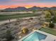 Backyard view showcases a refreshing pool and spa, putting green, and breathtaking mountain views at 10478 E Sheena Dr, Scottsdale, AZ 85255