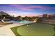 Spacious backyard with a pool, putting green, lounge chairs, and desert mountain views at 10478 E Sheena Dr, Scottsdale, AZ 85255