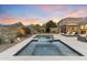 Beautiful backyard featuring a pool, spa, desert landscaping, and covered patio seating area at 10478 E Sheena Dr, Scottsdale, AZ 85255