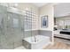 Bathroom with glass shower, soaking tub, mosaic tile, and access to main bedroom at 10478 E Sheena Dr, Scottsdale, AZ 85255