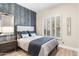 Bedroom with a wallpaper accent wall and shuttered window at 10478 E Sheena Dr, Scottsdale, AZ 85255