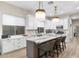 Elegant kitchen with white cabinets, marble countertops, modern pendant lighting, and ample natural light at 10478 E Sheena Dr, Scottsdale, AZ 85255
