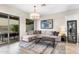 Bright living room featuring a large sectional sofa, elegant chandelier, and access to an outdoor patio at 10478 E Sheena Dr, Scottsdale, AZ 85255