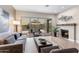 Cozy living room with fireplace, plush seating, and seamless access to the outdoor patio and pool at 10478 E Sheena Dr, Scottsdale, AZ 85255