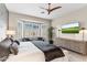 Bright main bedroom features a large window, TV, and decorative ceiling fan at 10478 E Sheena Dr, Scottsdale, AZ 85255