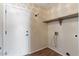 Spacious laundry room with hook, shelving, and white door leading to the exterior at 1061 E Linda Ln, Gilbert, AZ 85234