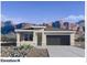 Charming single-story home featuring a two-car garage, desert landscaping, and picturesque mountain views at 10612 W Sonrisas St, Tolleson, AZ 85353