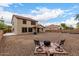 Wide view of a backyard with chairs surrounding a fire pit and a home with a red tiled roof at 12300 N 142Nd Ln, Surprise, AZ 85379