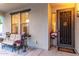 Inviting front porch with cozy seating, decorative plants, and a security door for added curb appeal at 12300 N 142Nd Ln, Surprise, AZ 85379