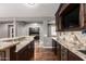 Wet bar area features a wine cooler, sink and granite countertops with custom cabinetry at 12473 W Montgomery Rd, Peoria, AZ 85383