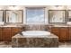 Bathroom featuring a large soaking tub, double vanity sinks, and granite counters at 12473 W Montgomery Rd, Peoria, AZ 85383