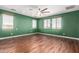 Spacious bedroom with wood floors, multiple windows, and a ceiling fan at 12473 W Montgomery Rd, Peoria, AZ 85383