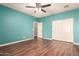 Well-lit bedroom featuring wood floors, ceiling fan, and a large closet at 12473 W Montgomery Rd, Peoria, AZ 85383