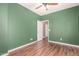 Bedroom with wood floors, closet, ceiling fan, and a doorway leading to an adjacent room at 12473 W Montgomery Rd, Peoria, AZ 85383