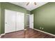 Bedroom with wood floors, closet and a doorway leading to an adjacent room at 12473 W Montgomery Rd, Peoria, AZ 85383