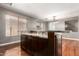 Elegant kitchen island featuring granite countertop and rich, dark cabinetry with wood floors at 12473 W Montgomery Rd, Peoria, AZ 85383