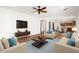 Open concept living room with modern furniture, ceiling fan, and wood-style flooring at 12473 W Montgomery Rd, Peoria, AZ 85383