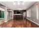 Spacious living room with hardwood floors, a built-in bar area, stainless steel fridge, and contemporary design elements at 12473 W Montgomery Rd, Peoria, AZ 85383
