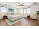 Spacious main bedroom featuring a ceiling fan, wood-style floors, and many windows at 12473 W Montgomery Rd, Peoria, AZ 85383