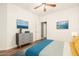 This beautifully staged bedroom has beach-themed decor with wood floors, a dresser and ensuite access at 12473 W Montgomery Rd, Peoria, AZ 85383