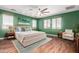 Nicely decorated main bedroom with a king bed, ceiling fan, and wood laminate floors at 12473 W Montgomery Rd, Peoria, AZ 85383