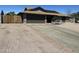 Exterior view of a charming home with a wide driveway, garage, and desert landscaping at 1316 N Spring Cir, Mesa, AZ 85203