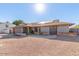 Charming single-story home with a well-manicured yard, desert landscaping, and solar panels at 1316 N Spring Cir, Mesa, AZ 85203