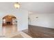 Spacious room with archway and transitions from hardwood to tile and a brick fireplace beyond at 1316 N Spring Cir, Mesa, AZ 85203