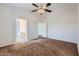 Bedroom with neutral walls, carpet, and a ceiling fan opens to the bathroom and closet at 13337 W Evans Dr, Surprise, AZ 85379