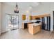Bright kitchen features an island, wooden cabinets, black appliances, and a sliding glass door to backyard at 13337 W Evans Dr, Surprise, AZ 85379