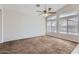 Bright living room with neutral carpet, a ceiling fan, and plenty of natural light at 13337 W Evans Dr, Surprise, AZ 85379