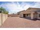 Large backyard with desert landscaping and a covered patio at 13414 W Maui Ln, Surprise, AZ 85379