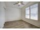 Bright bedroom features wood-look flooring, a ceiling fan, and plantation shutters at 13414 W Maui Ln, Surprise, AZ 85379
